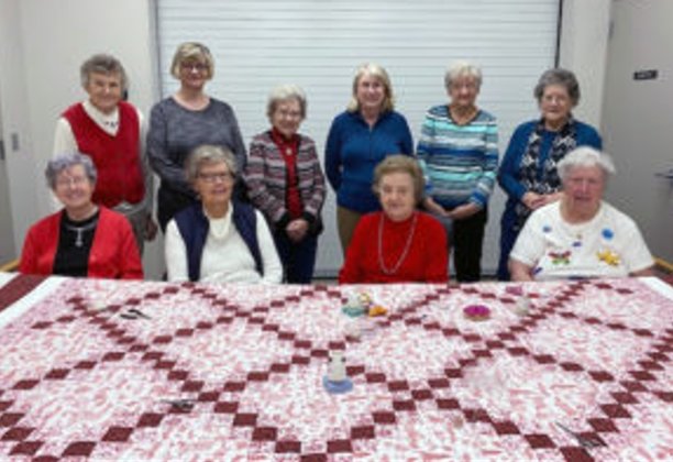 Members of the St. Rita’s Quilting Circle at St. Peter Parish in Jefferson City display an example of their handiwork.